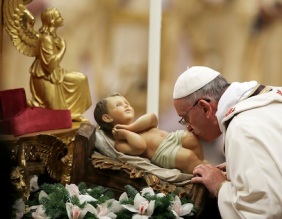 Pope Francis kisses a statue of baby Jesus as he celebrates the Christmas Eve Mass in St. Peter's Basilica at the Vatican, Tuesday, Dec. 24, 2013. (AP Photo/Gregorio Borgia)