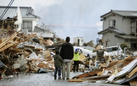 A father and child who lost their home stand in front of debris in Sendai, northern Japan Saturday, March 12, 2011 after Japan's biggest recorded earthquake slammed into its eastern coast Friday. (AP Photo/Kyodo News) MANDATORY CREDIT, NO LICENSING ALLOWED IN CHINA, HONG KONG, JAPAN, SOUTH KOREA AND FRANCE